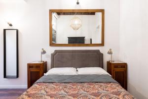 a bedroom with a bed with a mirror on the wall at Appartamento trastevere Roma in Rome