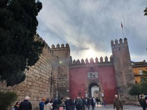 a crowd of people standing outside of a castle at Hostal Puerta Carmona in Seville