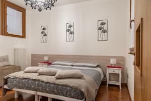 1 Schlafzimmer mit 2 Betten und einem Kronleuchter in der Unterkunft Ca' Latina - Cozy home in pieno centro storico in Treviso
