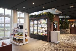 ein Lebensmittelgeschäft mit einem großen Kühlschrank mit Getränken in der Unterkunft NH Frankfurt Airport in Kelsterbach