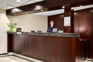 une femme debout à un comptoir de réception dans un bureau dans l'établissement NH Arnhem Rijnhotel, à Arnhem