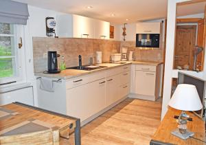 a kitchen with white appliances and a wooden floor at Ferienwohnung an der Granitz in Ostseebad Sellin