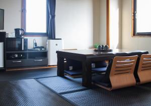 a dining room with a table and two chairs at Hotel Livemax BUDGET Kanazawa-Idaimae in Uchinada