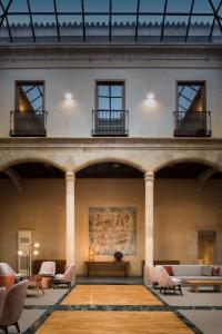 Habitación grande con sillas y mesas en un edificio en NH Collection Salamanca Palacio de Castellanos, en Salamanca