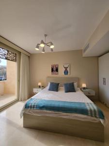 Un dormitorio con una cama grande y una ventana. en Mangroovy Ritzy, Cerulean appartement by the pool, en Hurghada