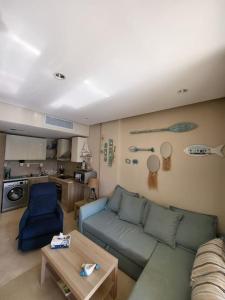 una sala de estar con un sofá y una mesa en Mangroovy Ritzy, Cerulean appartement by the pool, en Hurghada