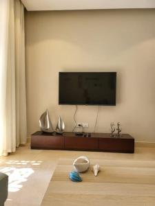 a living room with a flat screen tv on a wall at Mangroovy Ritzy, Cerulean appartement by the pool in Hurghada