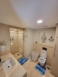 a bathroom with a toilet and a shower and a sink at Mangroovy Ritzy, Cerulean appartement by the pool in Hurghada