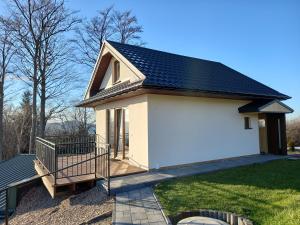 Cicha Chata Kudłacze في Pcim: منزل أبيض صغير على سقف أسود