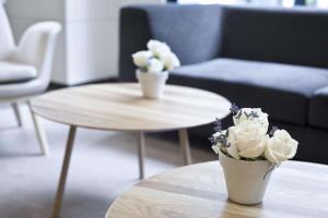 due vasi con fiori su un tavolo in soggiorno di NH Canciller Ayala Vitoria a Vitoria-Gasteiz