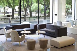 a lobby with a couch and tables and chairs at NH Canciller Ayala Vitoria in Vitoria-Gasteiz