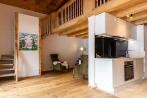 Habitación con cocina y sala de estar con suelo de madera. en Monte Vita Tirol - Apartments, en Biberwier
