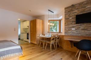 1 dormitorio con 1 cama y 1 mesa con sillas en Monte Vita Tirol - Apartments, en Biberwier