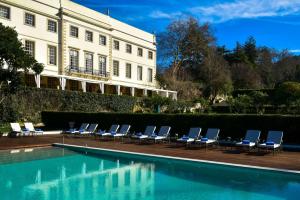 a row of lounge chairs next to a swimming pool at Tivoli Palacio de Seteais - The Leading Hotels of the World in Sintra
