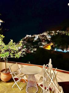 a table and chairs on a balcony at night at Santiago vacation home in Positano in Positano