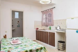 uma cozinha com uma mesa, um lavatório e um frigorífico em Chryssa Studios em Argasi