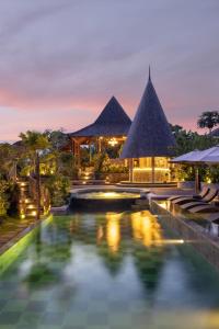 a resort with a swimming pool at night at The Alena a Pramana Experience in Ubud