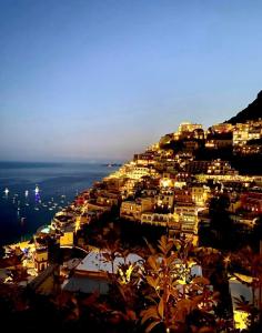 Santiago vacation home in Positano في بوسيتانو: بلدة على قمة تل في الليل