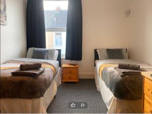 a room with two beds and a window at Tudor Lodge - Redcar Beach in Redcar