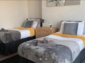 1 dormitorio con 2 camas y toallas. en Tudor Lodge - Redcar Beach, en Redcar