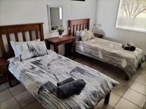 a bedroom with two beds and a mirror at Mukumbura Swartwater 