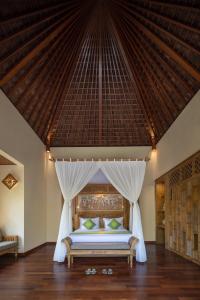 1 dormitorio con 1 cama con dosel en The Alena a Pramana Experience en Ubud
