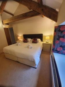 1 dormitorio con 1 cama blanca grande y 2 lámparas en Clifton Cottage at Lovelady Shield, en Alston