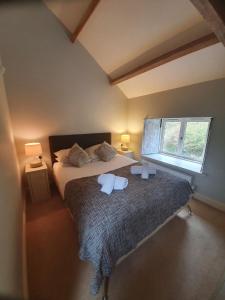 Un dormitorio con una cama grande y una ventana en Clifton Cottage at Lovelady Shield, en Alston