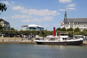 ein Boot im Wasser vor einem Gebäude in der Unterkunft Séjours & Affaires Nantes Ducs De Bretagne in Nantes