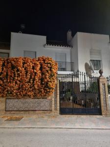 um edifício com uma cerca com um ramo de flores em Casa adosada - Los Boliches - Fuengirola em Fuengirola