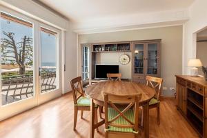 una sala da pranzo con tavolo e vista sull'oceano di ApartmentsGarda - Residenza Dei Navigatori a Torri del Benaco