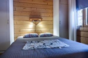 a bedroom with a bed with a wooden wall at Himos Huili 2 in Himos
