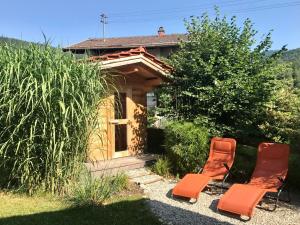 two orange chairs sitting in front of a house at Chalet Chiemgau in Schleching