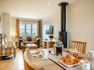 a kitchen and living room with a wood stove at Daisy Cottage - Uk38683 in Oxhill