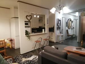 a living room and kitchen with a couch and chairs at Rivitalokaksio Jäppilässä in Jäppilä