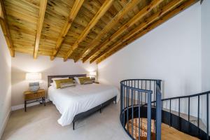 马拉加Homely Málaga Mariblanca 17, Vegafuente Apartments的带床和木质天花板的卧室