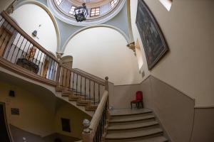una escalera en un edificio con una silla roja en Hospederia Seminario Conciliar de San Julián, en Cuenca