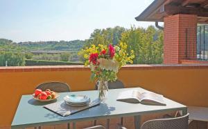 een tafel met een vaas met bloemen en een boek bij Appartamento la Goccia - Gardagate in San Felice del Benaco