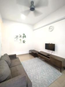sala de estar con sofá y TV de pantalla plana en D'Indah59 KLIA Homestay, en Sepang
