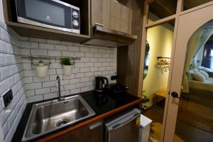 a small kitchen with a sink and a microwave at Krung Boutique Hotel in Bangkok
