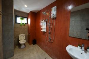 a bathroom with a shower and a toilet and a sink at Krung Boutique Hotel in Bangkok