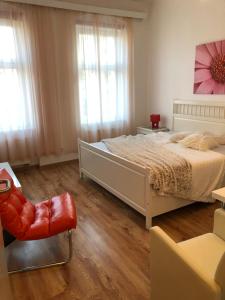 um quarto com uma cama grande e uma cadeira em Apartmány Galeta em Karlovy Vary