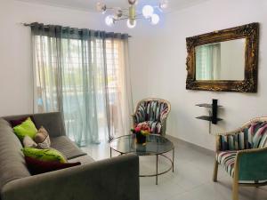 a living room with a couch and a glass table at Oasis Palma Real santiago, Republica Dominicana in Santiago de los Caballeros