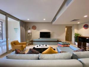 ein Wohnzimmer mit 2 Sofas und einem TV in der Unterkunft Mangroovy - Buena Vista Pool and Marina views in Hurghada