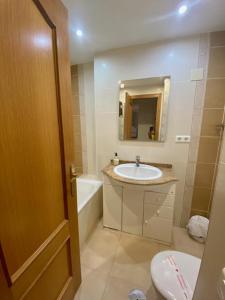 ein Badezimmer mit einem Waschbecken, einem WC und einem Spiegel in der Unterkunft Acapulco Playa BLUEWATER VILLAS in Nerja
