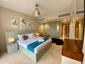 ein Schlafzimmer mit einem großen Bett und einem Schreibtisch. in der Unterkunft Mangroovy - Buena Vista Pool and Marina views in Hurghada