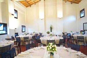 a banquet hall with white tables and chairs with flowers at Principessa Pio in Ferrara