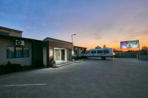 een busje geparkeerd op een parkeerplaats naast een gebouw bij Phudzi Hotel in Letlhakawe