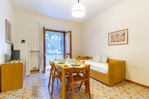 ein Schlafzimmer mit einem Tisch und einem Bett sowie einem Tisch und Stühlen in der Unterkunft Appartamento La Poesia Bilo 2 - MyHo Casa in Tortoreto Lido