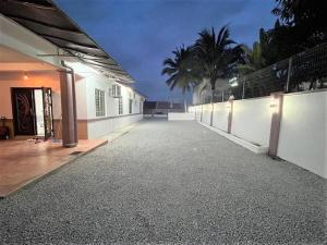 a building with a walkway next to a wall at Home of Camper 659 in Seremban (16-18Pax) in Seremban
